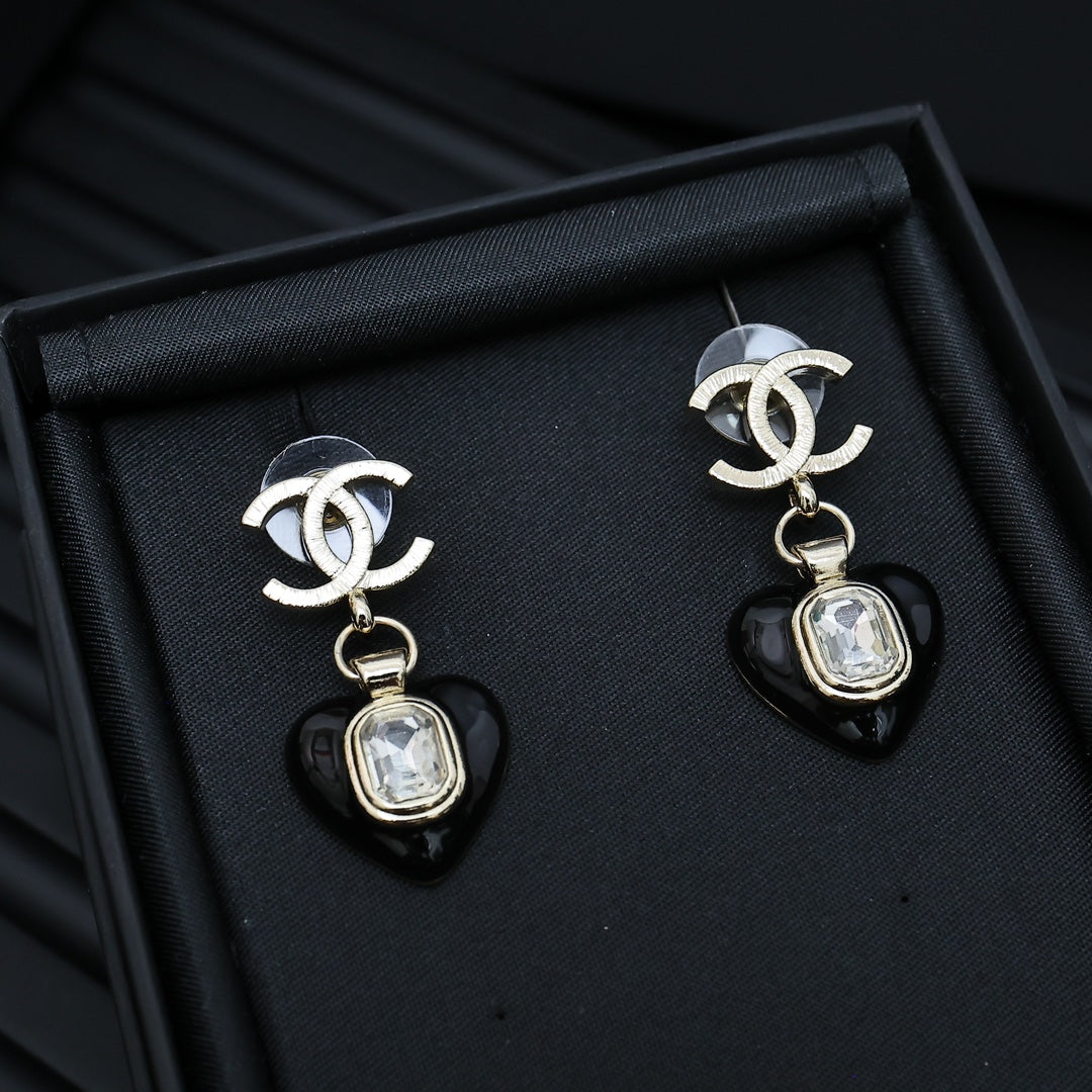 Chanel earrings with silver CC tops and black heart charms with clear crystal