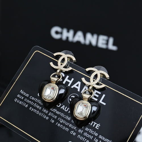 Chanel earrings featuring silver CC links and black heart charms with clear crystal