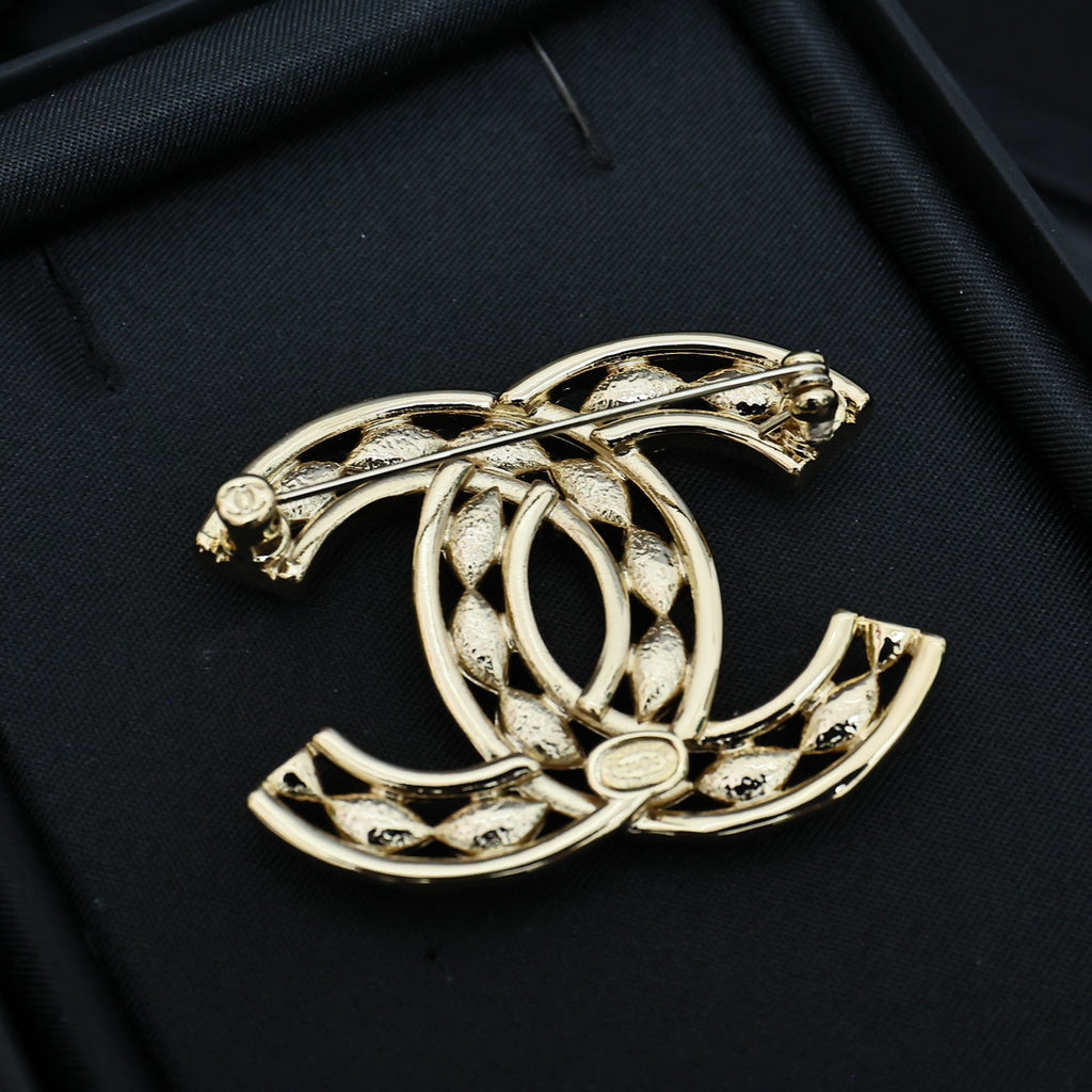 Chanel jeweled CC-style brooch, gold-tone with crystal accents, angled view
