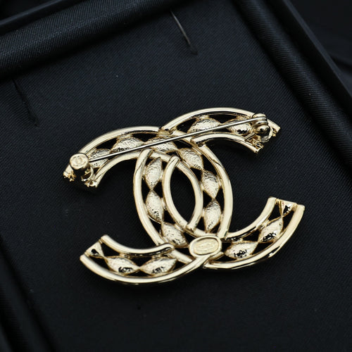 Chanel jeweled CC-style brooch, gold-tone with crystal accents, angled view
