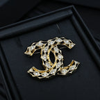 Chanel jeweled CC-style brooch with gold-tone settings and clear crystals