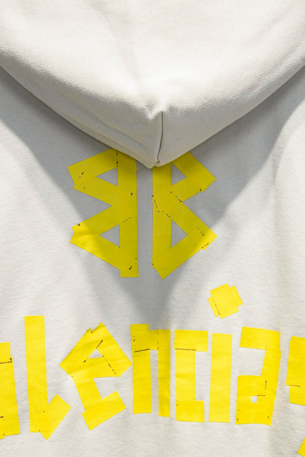 Off-white hoodie close-up with hood seam and yellow logo graphic