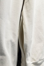 Off-white hoodie side view with sleeve seam and curved hem