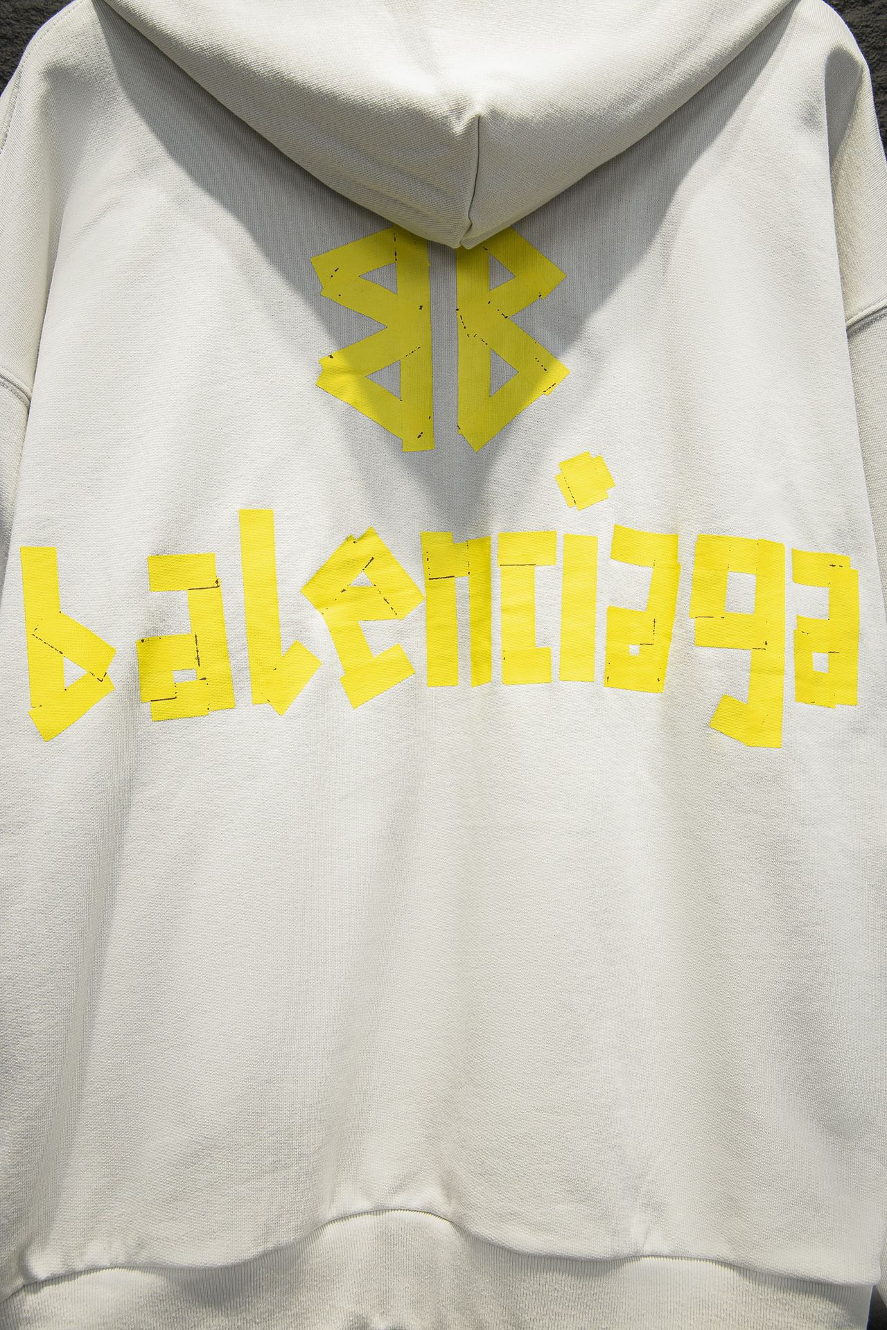 Off-white hoodie with hood and large yellow back graphic logo