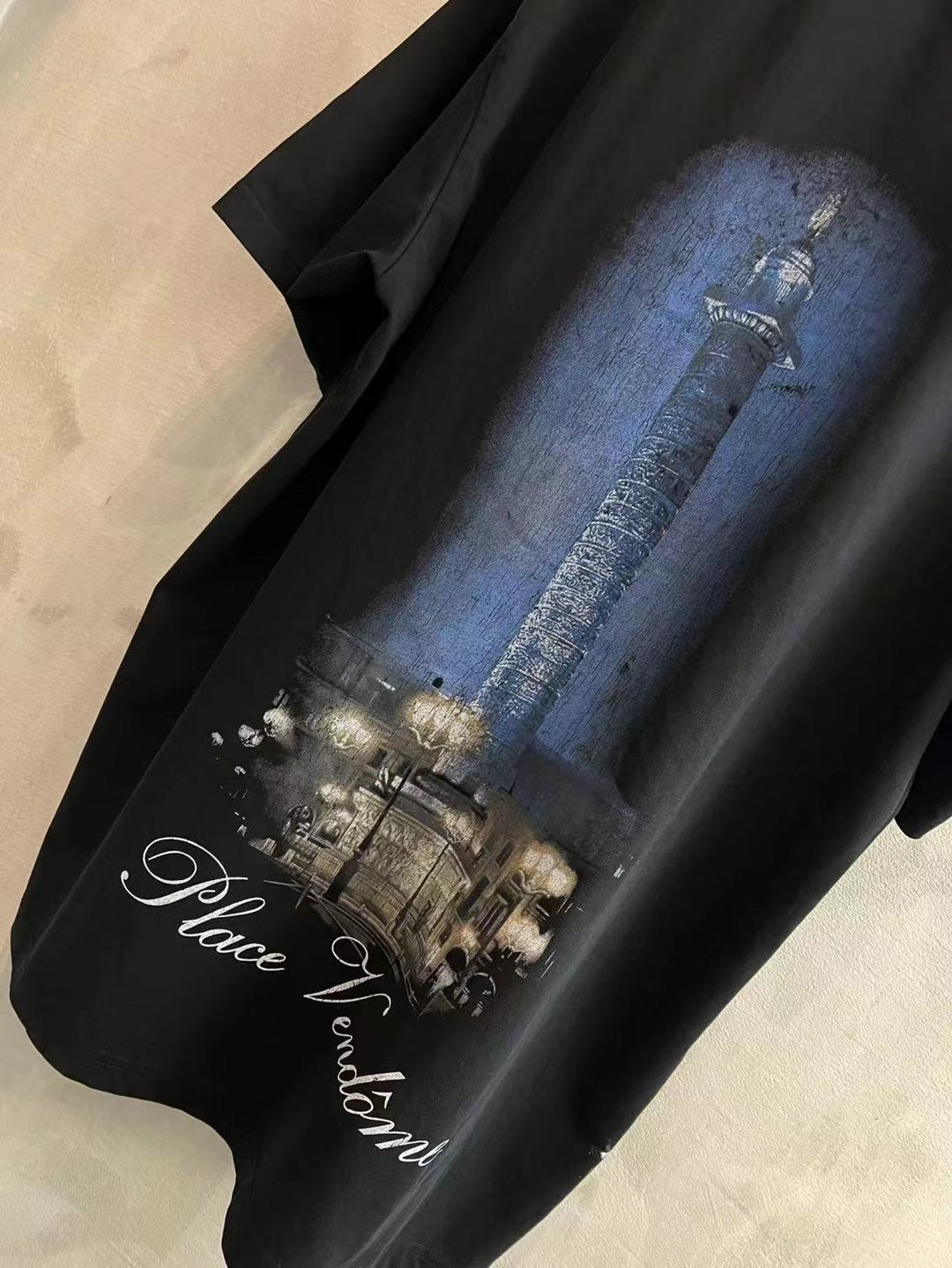Black T-shirt with blue column graphic and Place Vendome script