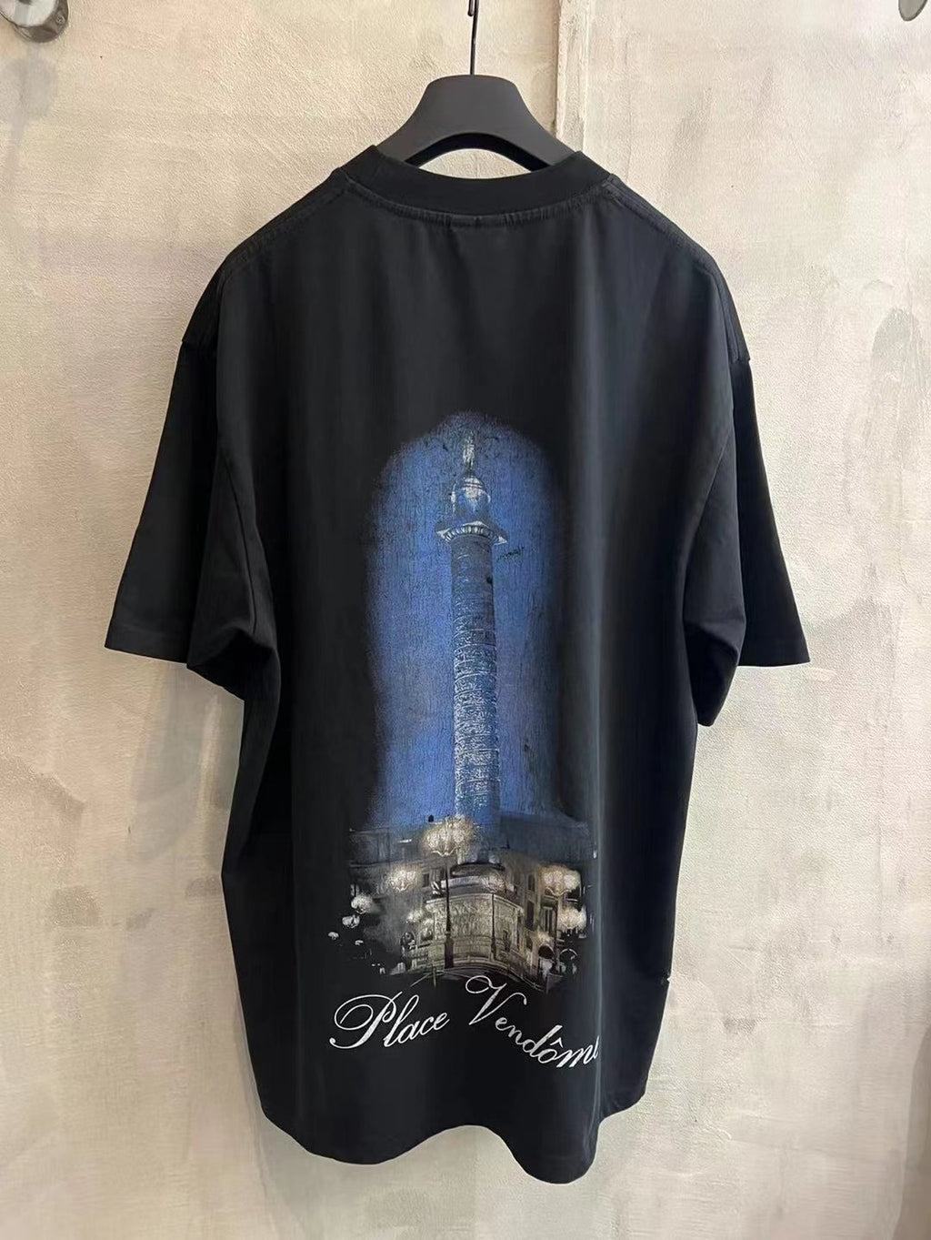 Black crew-neck T-shirt with blue column graphic and Place Vendome text