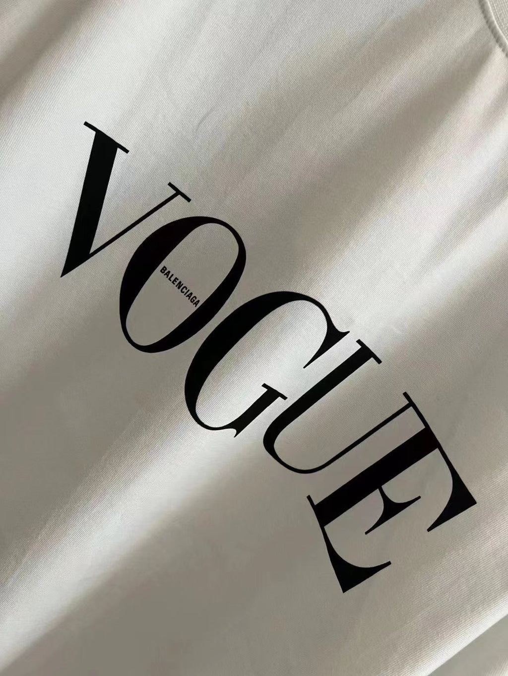 White crewneck T-shirt with large black 'Vogue' graphic detail.