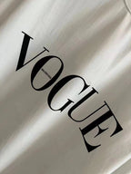 White T-shirt sleeve close-up with large black "VOGUE" graphic