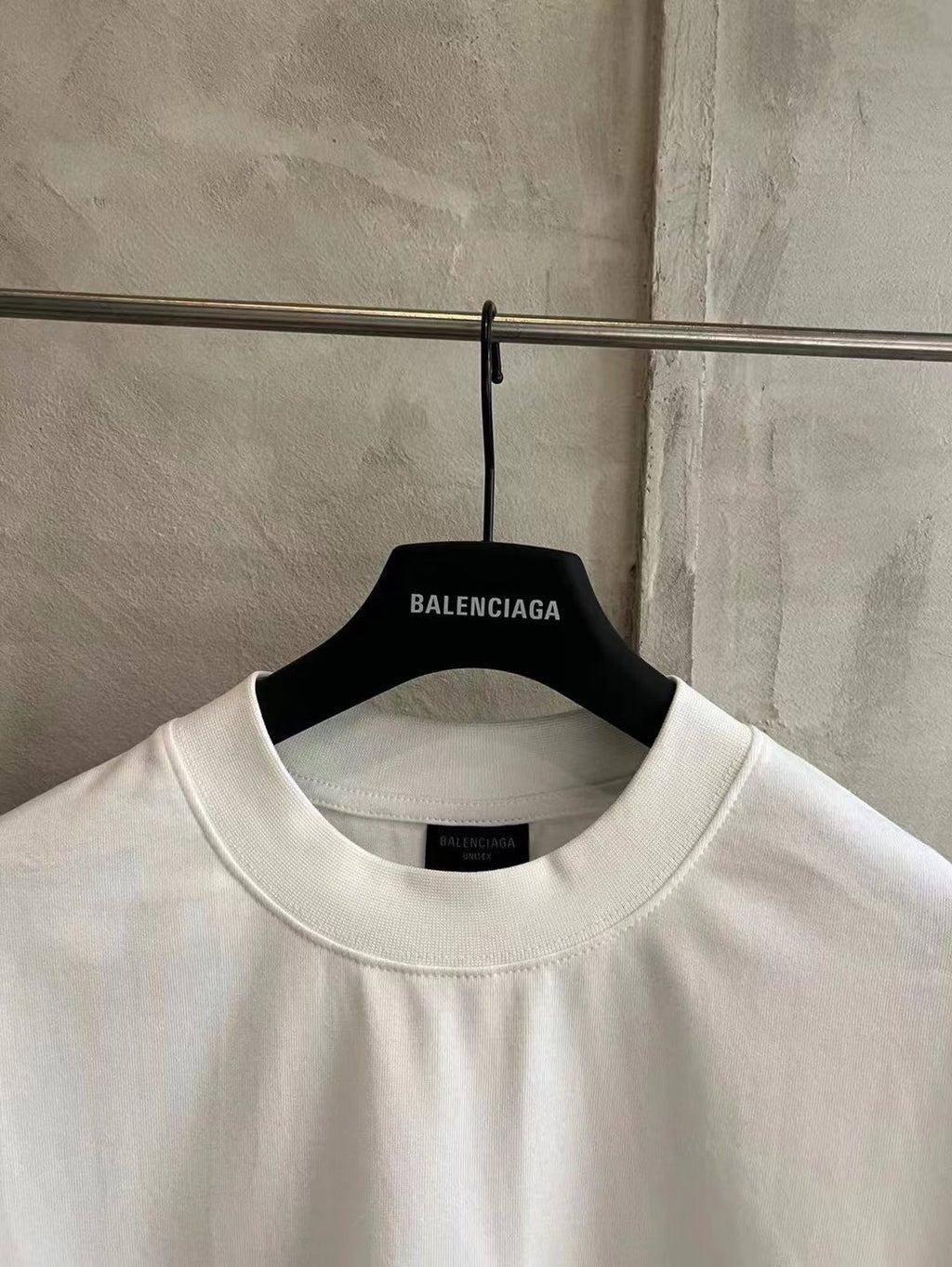 White crewneck T-shirt with Balenciaga logo at the neckline.