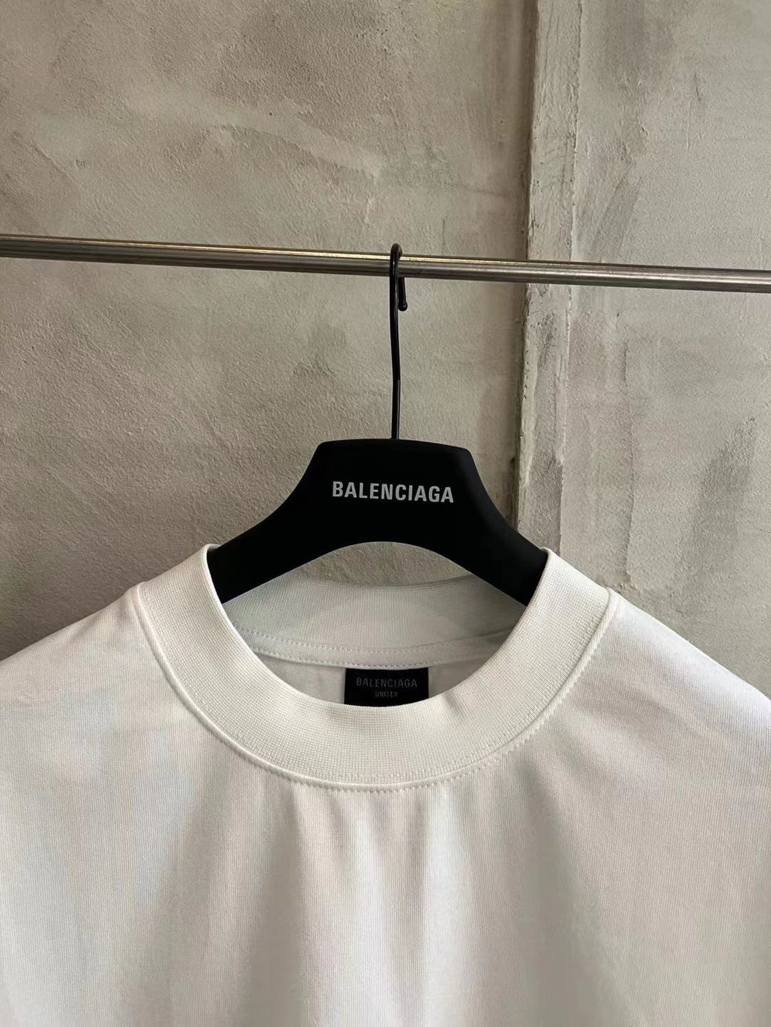 White crewneck T-shirt with Balenciaga logo at the neckline.