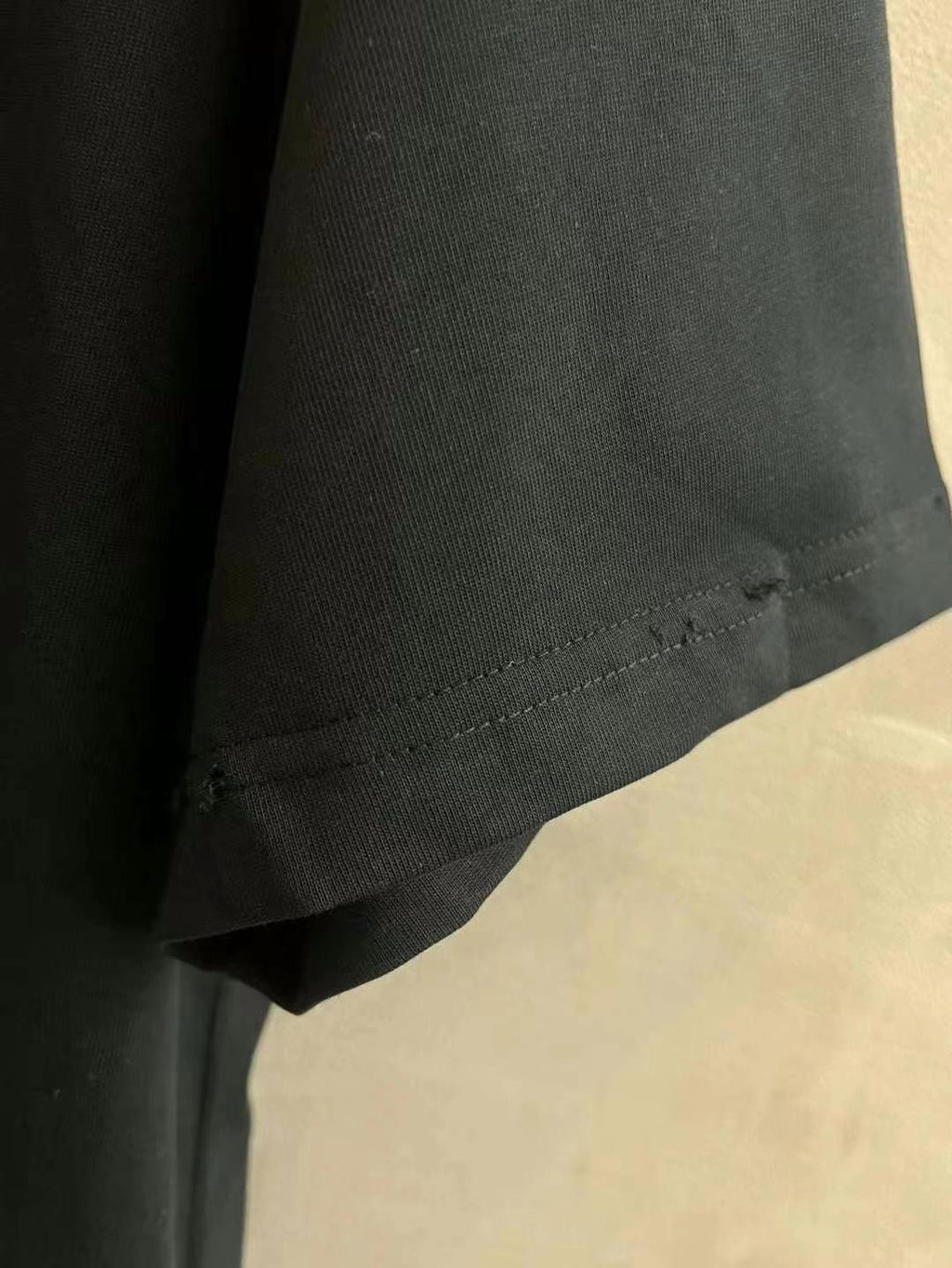 Black T-shirt hem with visible stitching detail