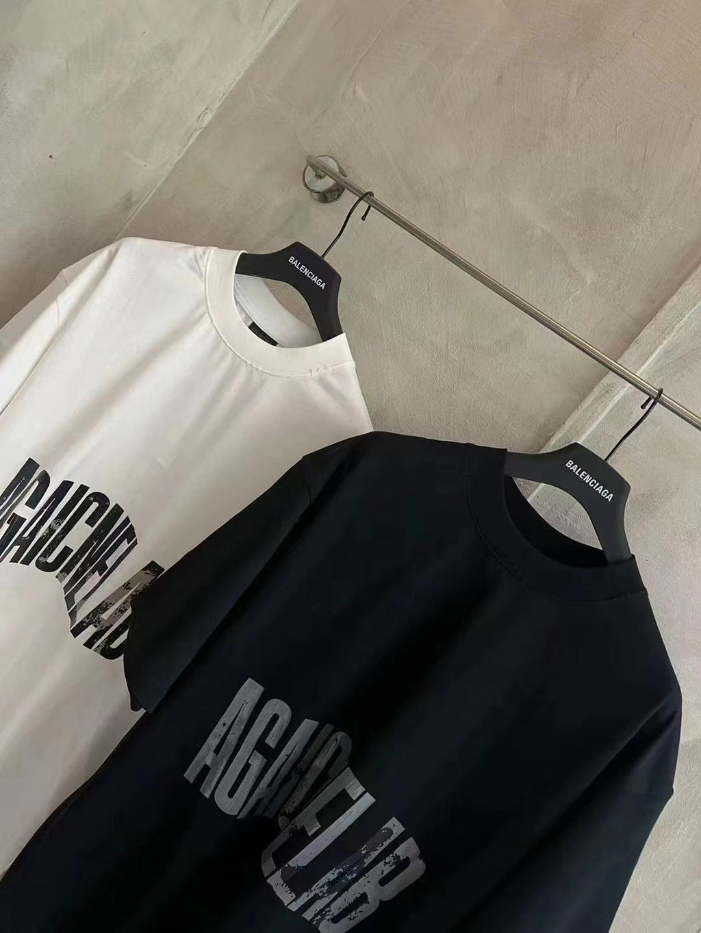 Balenciaga graphic T-shirts set: white and black, both with AGAINCELAB logo text