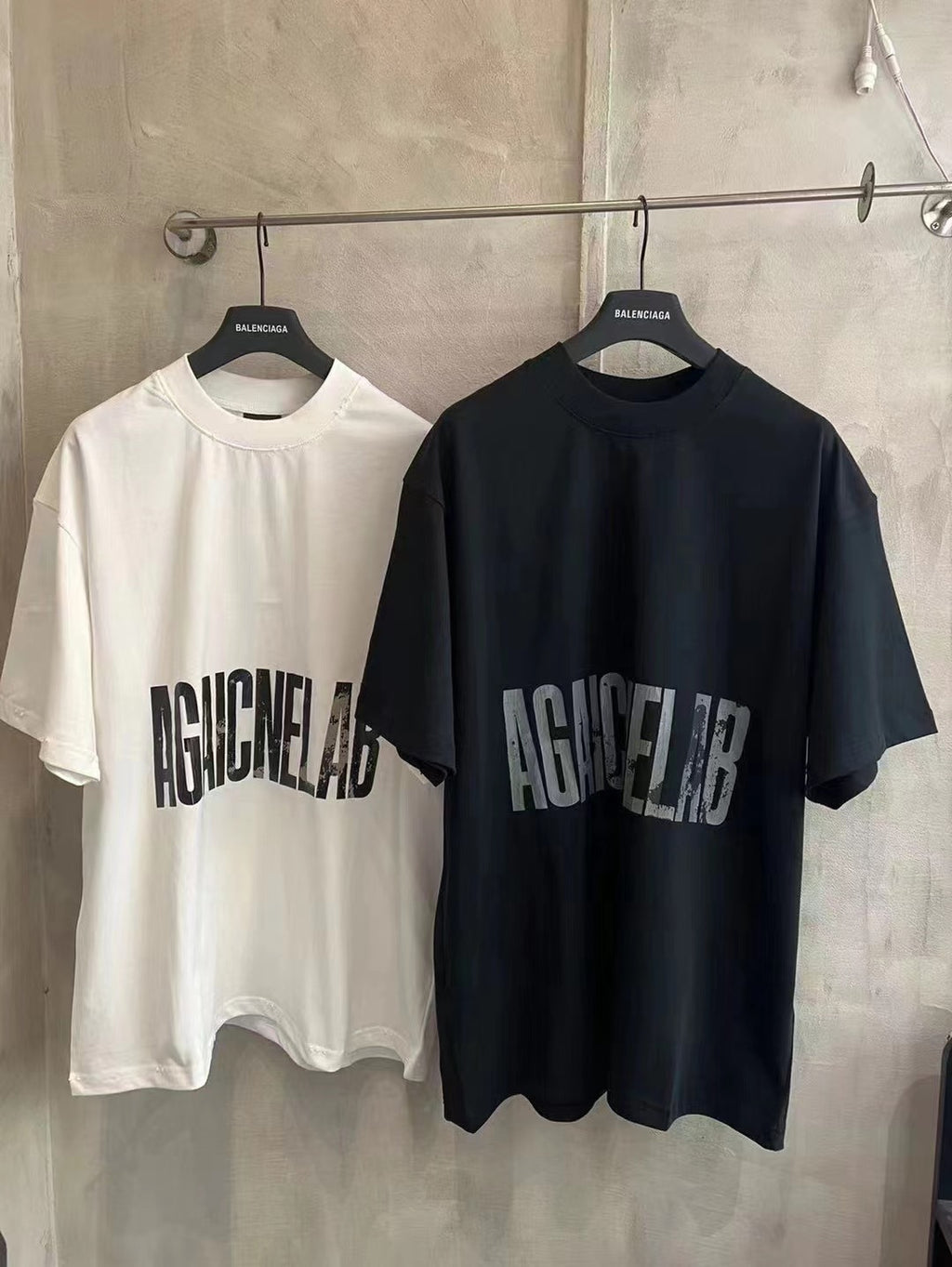 Balenciaga pair of graphic T-shirts: white and black with AGAINCELAB logo print
