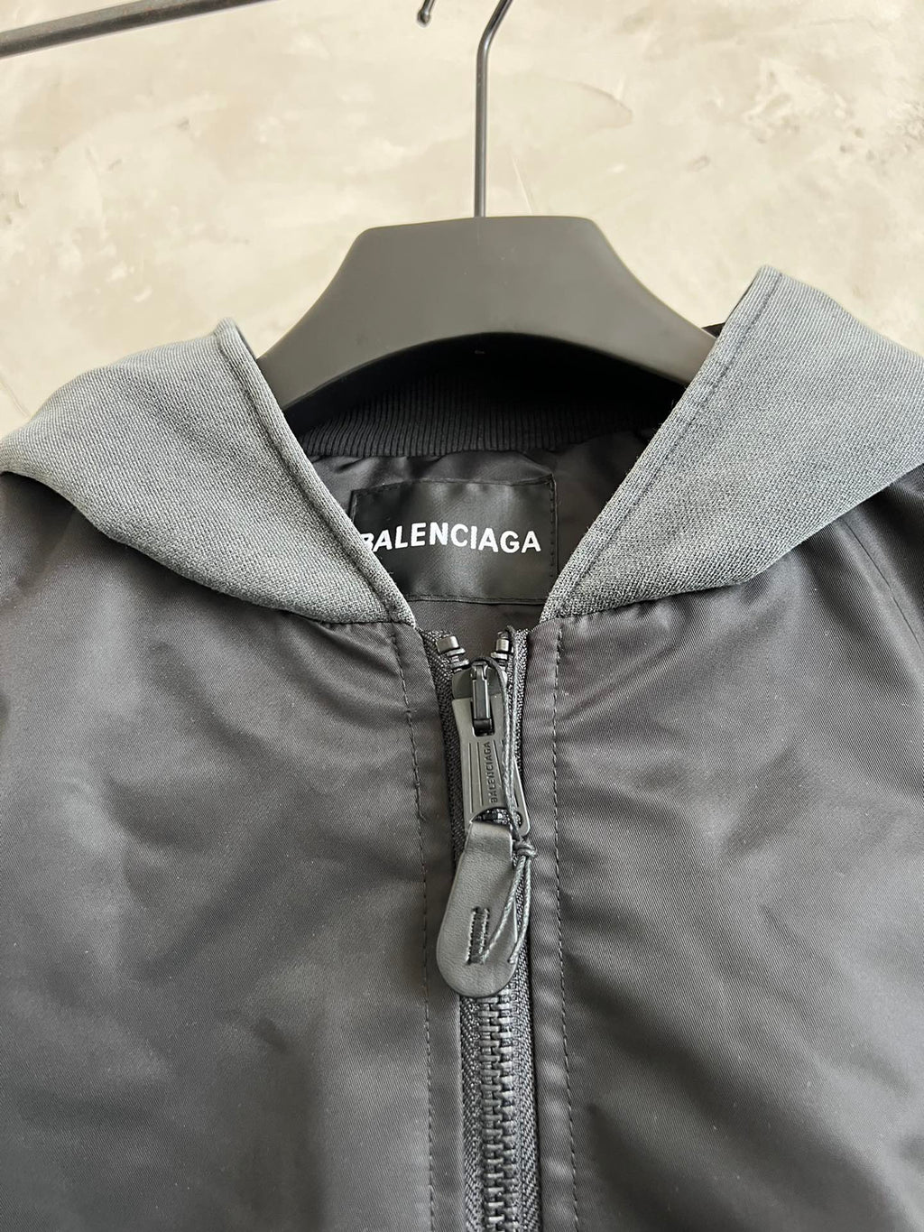 Dark zip hooded jacket with heather gray hood and metal zipper pull