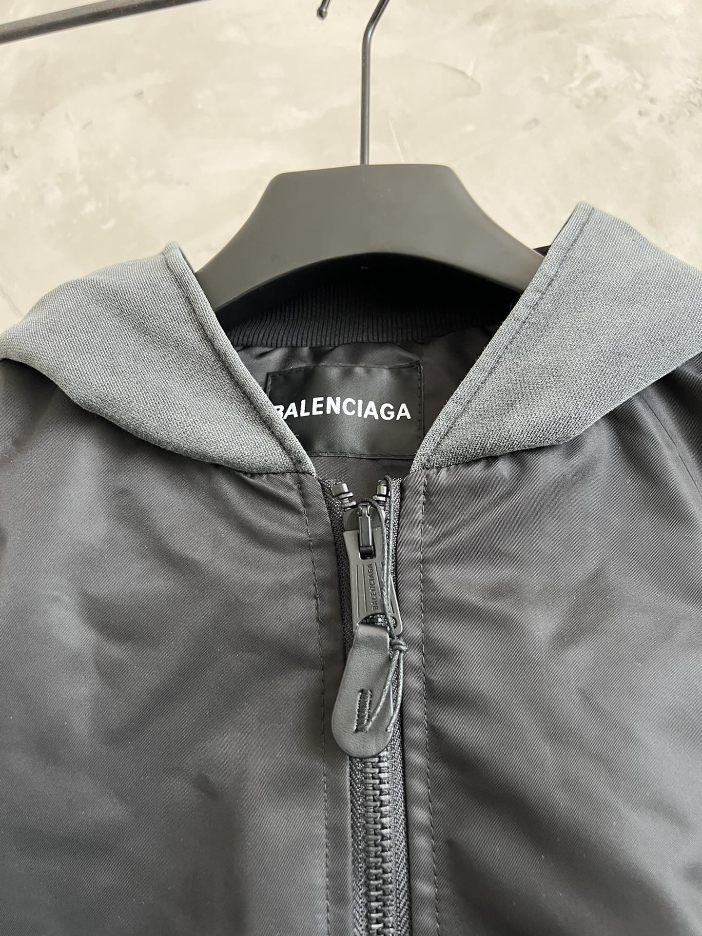 Dark zip hooded jacket with heather gray hood and metal zipper pull