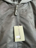 Dark zip hooded jacket with metal zipper and beige brand hang tag
