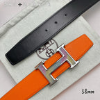 Orange belt with black leather strap with holes and silver-tone H buckle detail