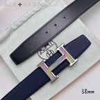 Navy leather belt close-up with gold H buckle on textured strap