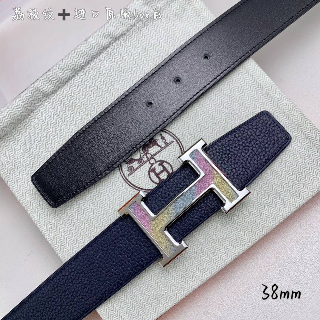 Navy leather belt close-up with gold H buckle on textured strap