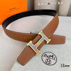 Tan leather belt with gold-tone and silver-tone H buckle, adjustable holes
