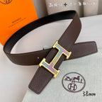Brown leather belt with gold and silver H buckle and side keeper tab