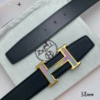 Leather belt buckle close-up: gold H hardware with purple inlay on black strap