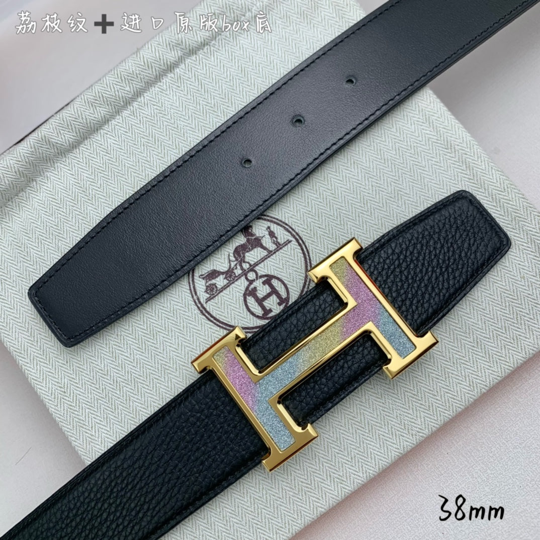 Leather belt buckle close-up: gold H hardware with purple inlay on black strap