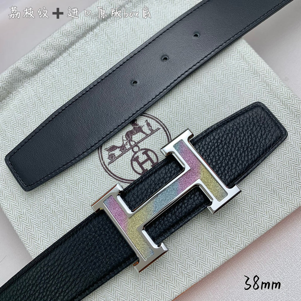 Leather belt buckle close-up: gold H clasp with purple accents on black strap