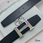 Leather belt buckle close-up: gold H clasp with purple accents on black strap