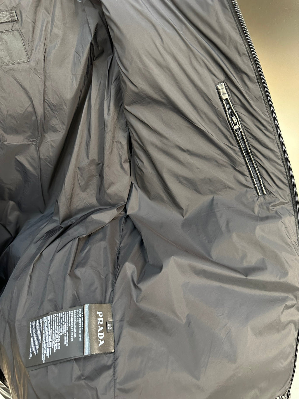 Prada long puffer jacket interior with front zipper and care label