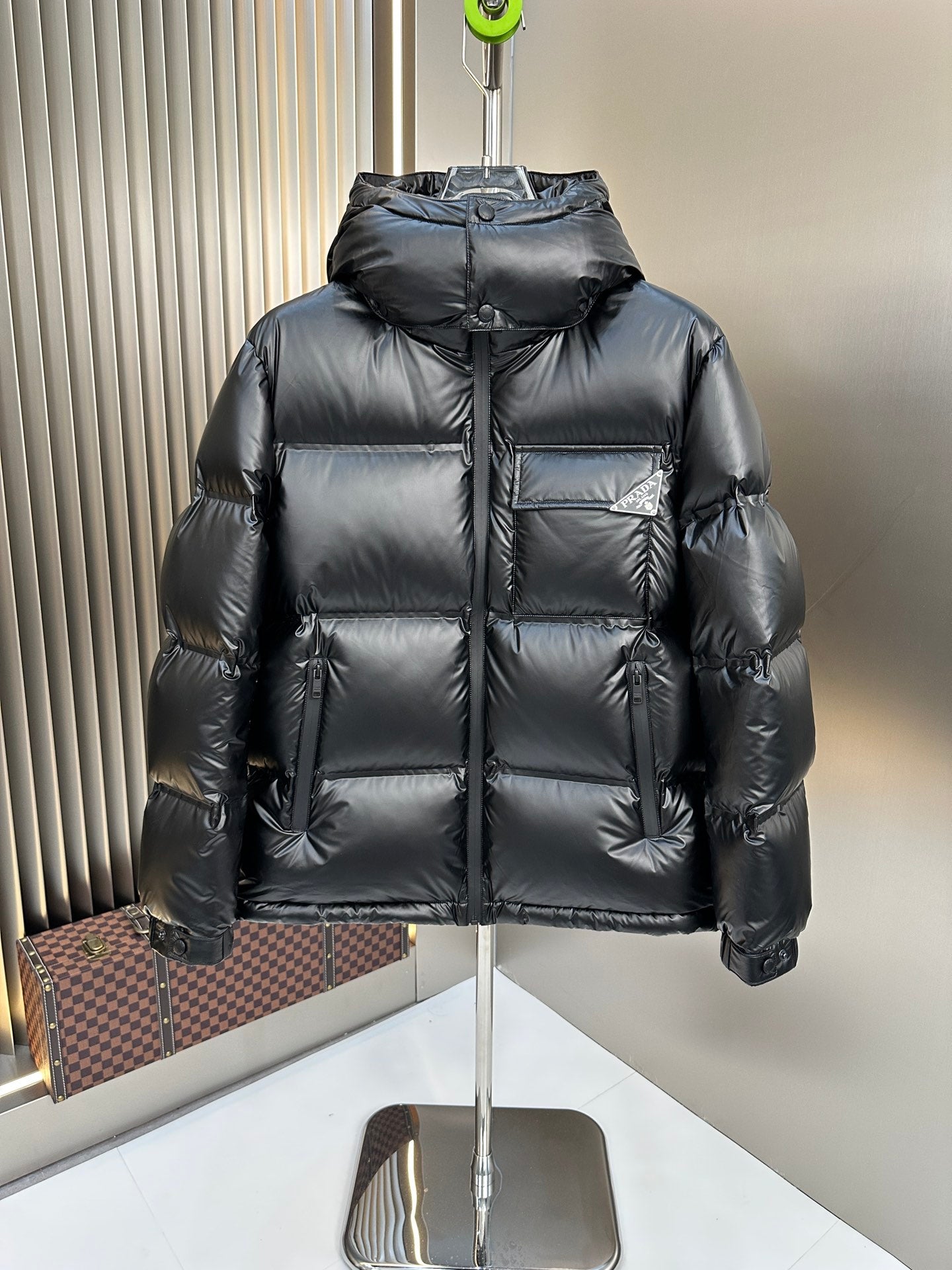 Prada hooded long puffer jacket in dark color, quilted panels and front zipper
