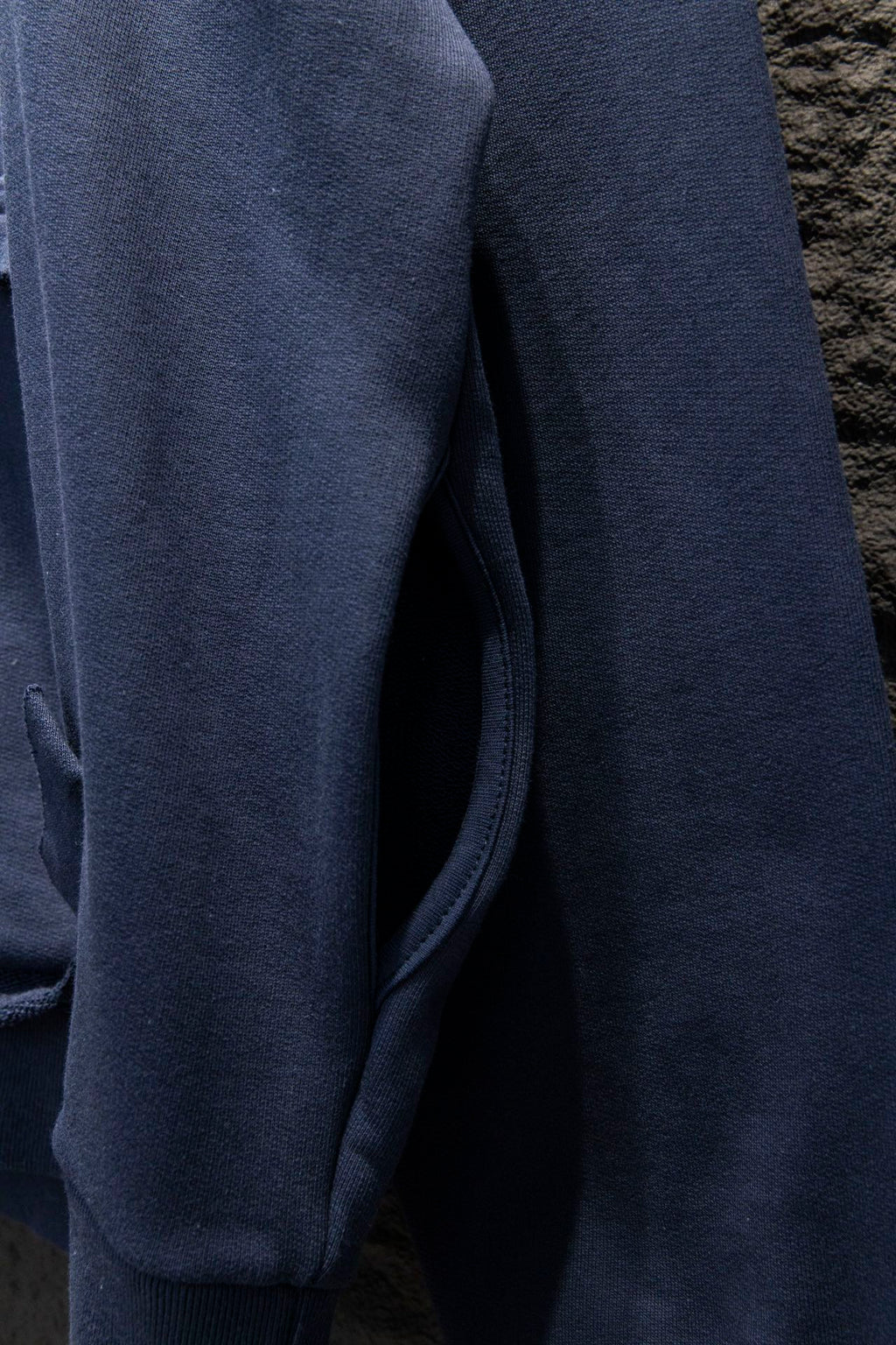 Balenciaga hoodie side view with ribbed cuff and dark blue fabric