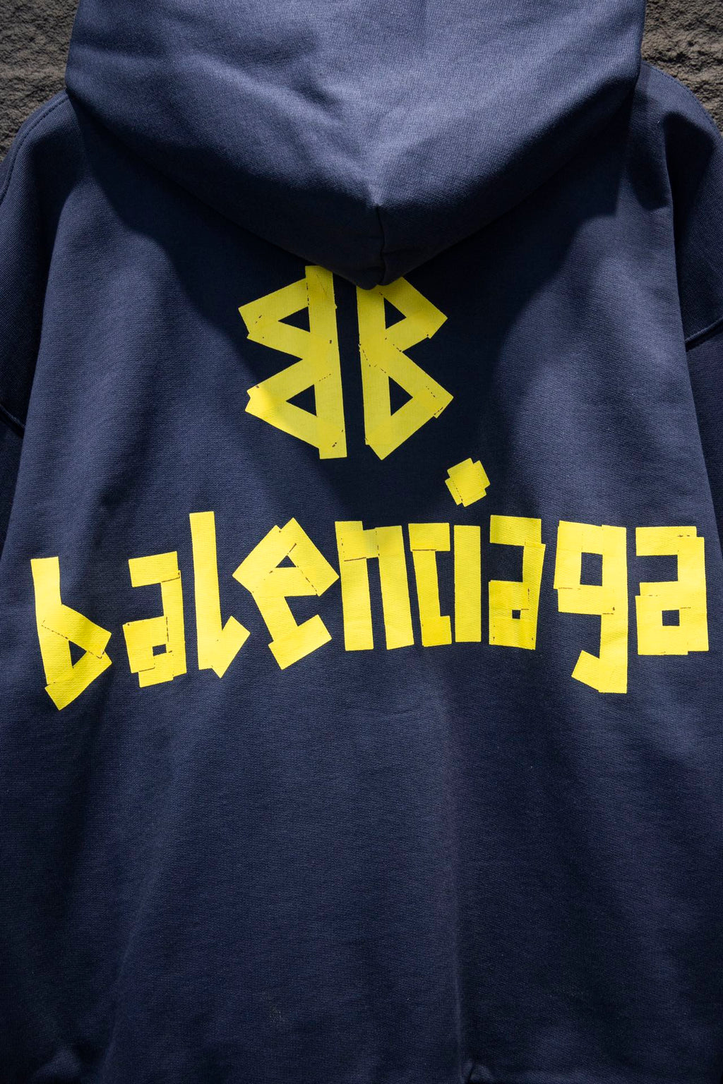 Balenciaga hoodie close-up with yellow graphic logo on the back