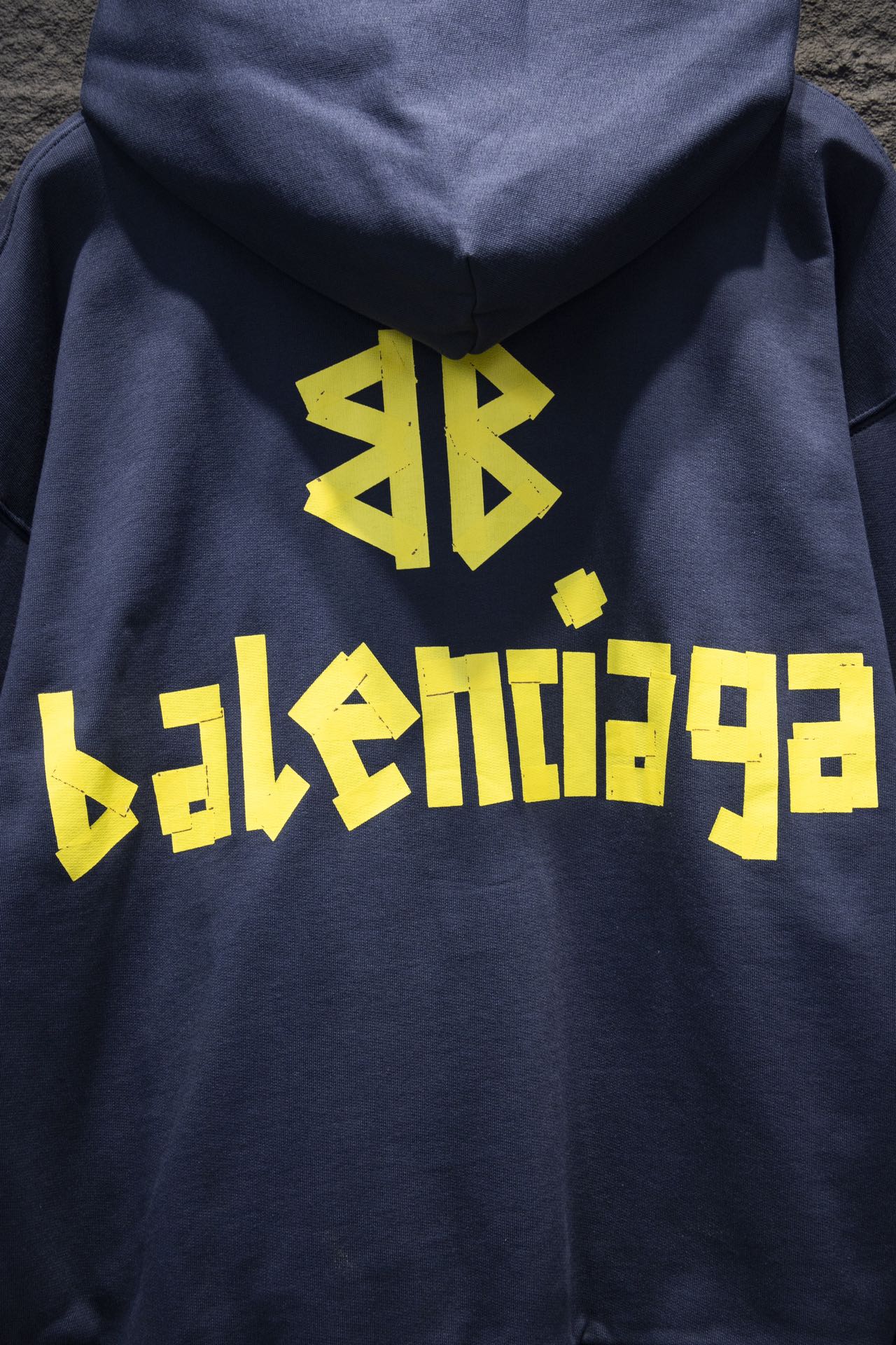 Balenciaga hoodie close-up with yellow graphic logo on the back