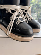 Amiri black high-top sneakers close-up of cream laces and logo patch