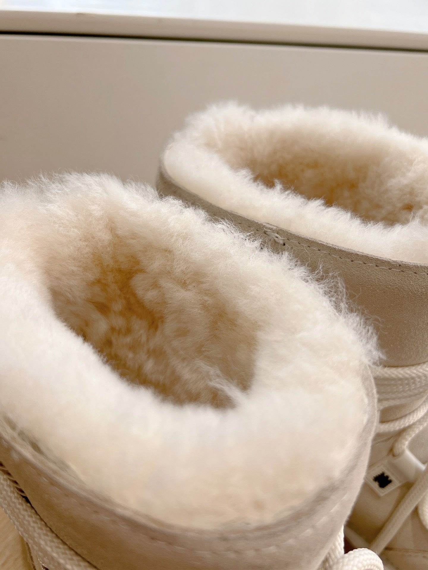 Close-up of beige faux fur lining on a lace-up boot collar