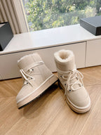 Beige suede ankle boots with white laces and plush fur collar