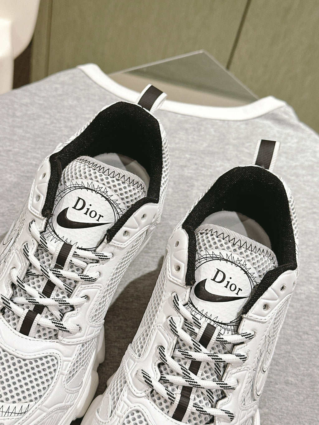 Close-up: white lace-up sneaker with Dior logo on tongue and mesh paneling