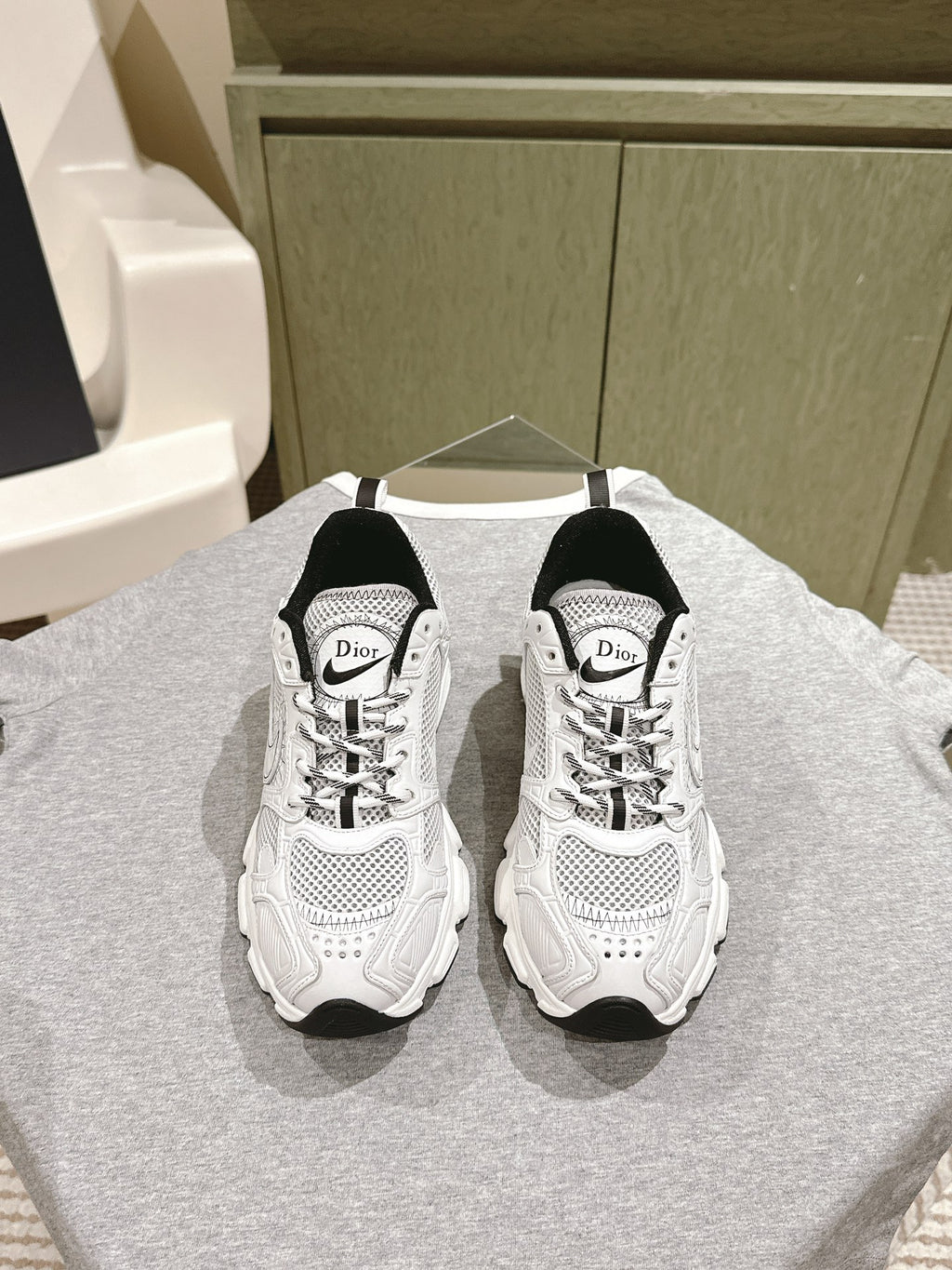 White lace-up sneakers with Dior logo, black heel panels, perforated mesh uppers