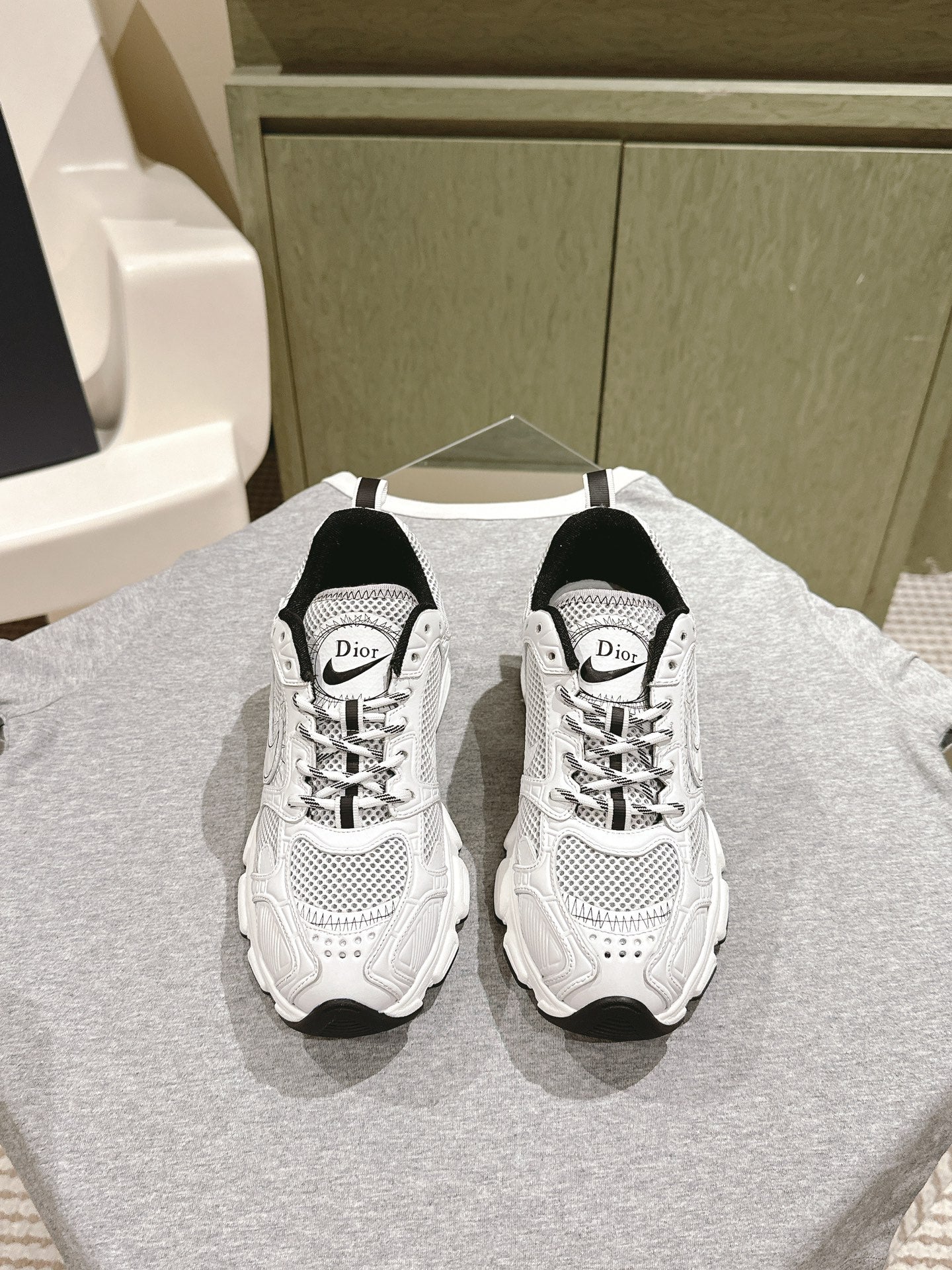 White lace-up sneakers with Dior logo, black heel panels, perforated mesh uppers
