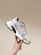 White lace-up sneaker held up: perforated mesh upper with Dior branding
