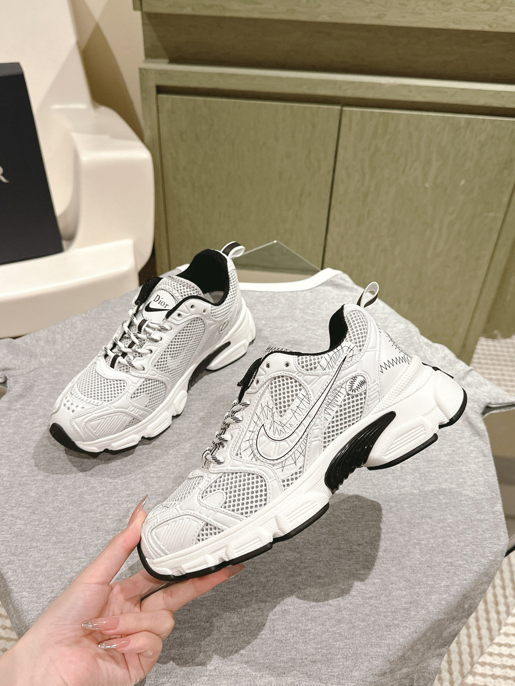 White lace-up sneakers with Dior logo, swoosh detail, black sole accents