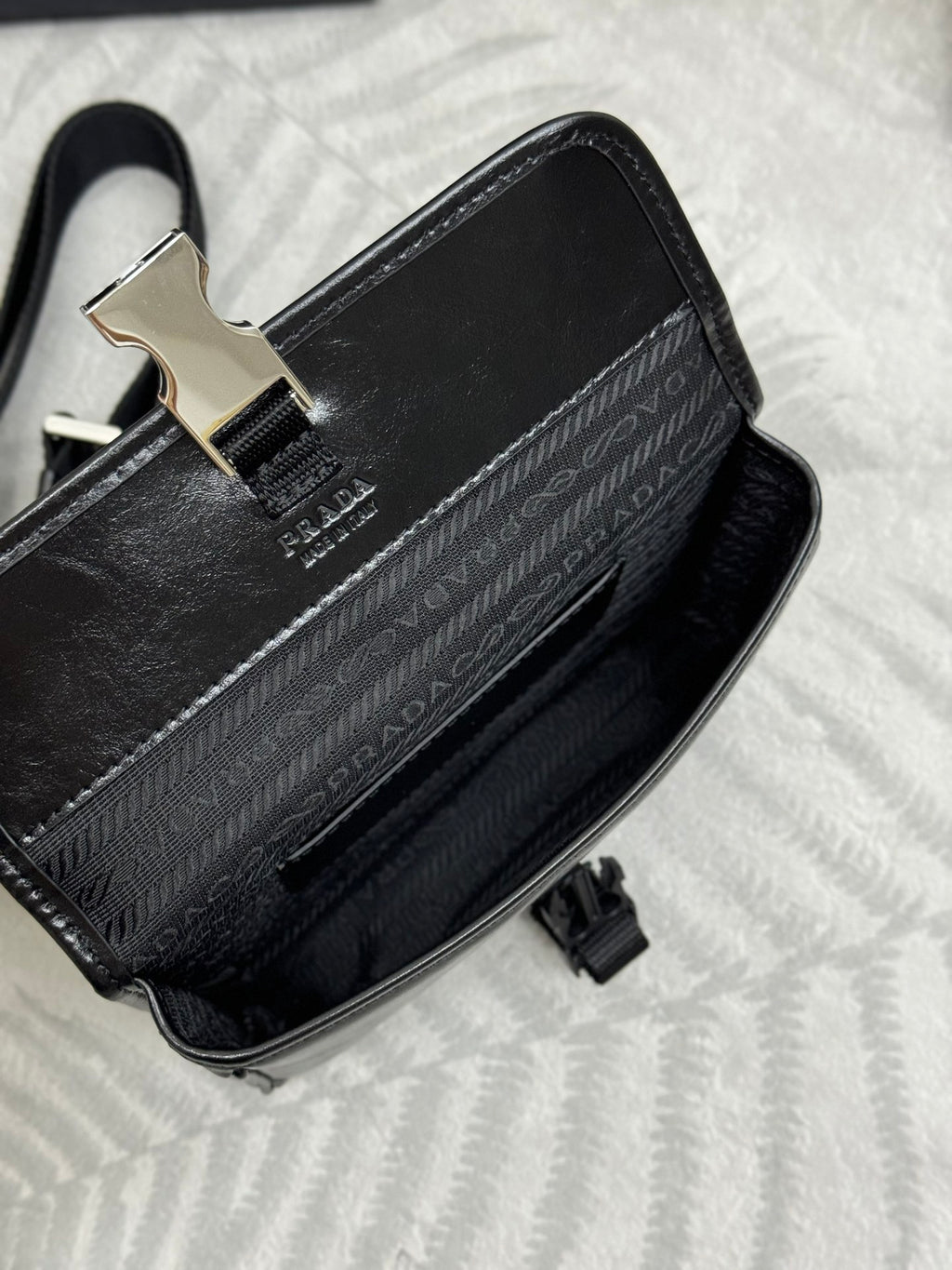 Prada bag black with jacquard logo panel, silver clasp, and top strap hardware