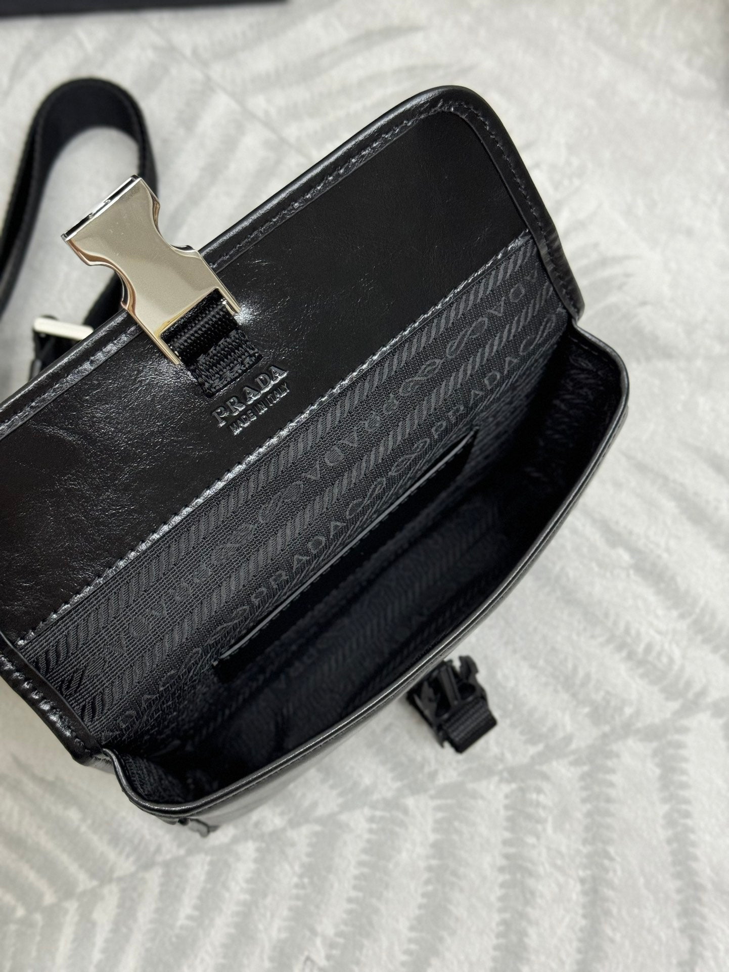 Prada bag black with jacquard logo panel, silver clasp, and top strap hardware