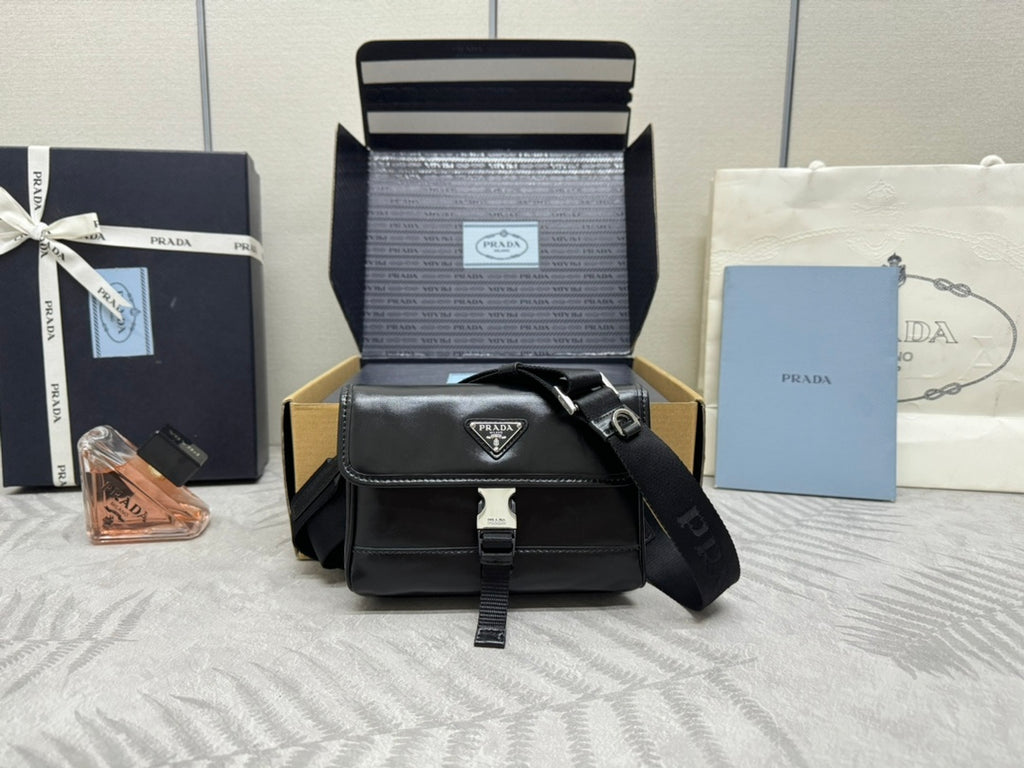 Prada bag in black with front flap, silver logo plaque, and adjustable crossbody strap
