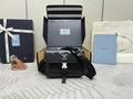 Prada bag in black with front flap, silver logo plaque, and adjustable crossbody strap