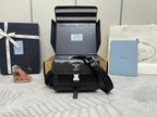 Prada bag in black with front flap, silver logo plaque, and adjustable crossbody strap