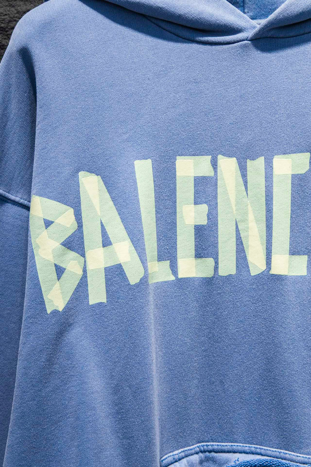 Light blue hoodie chest graphic with stylized “BALENCI…” lettering in pale blue and white