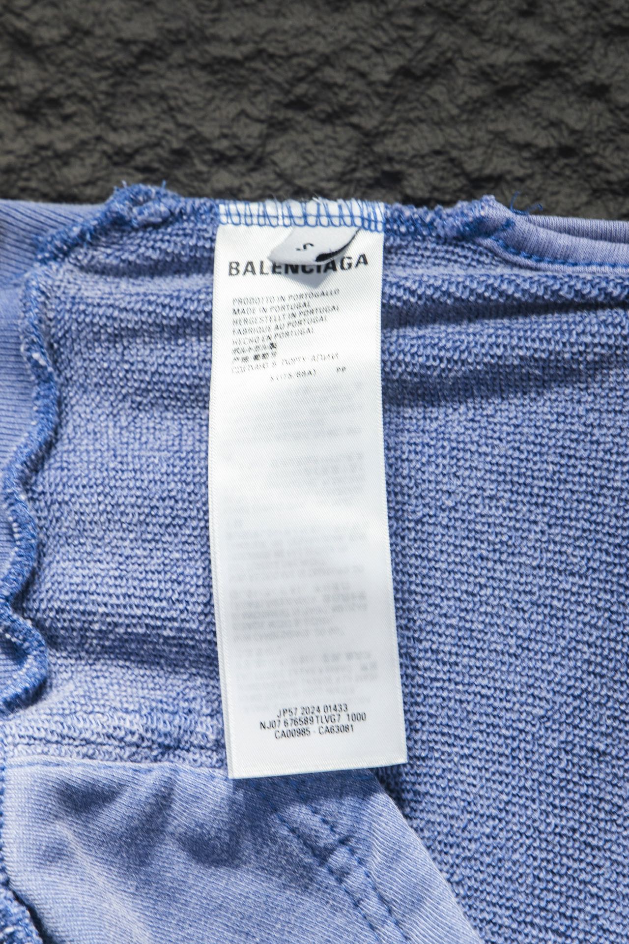 Light blue hoodie inside label at hem with printed size and care information