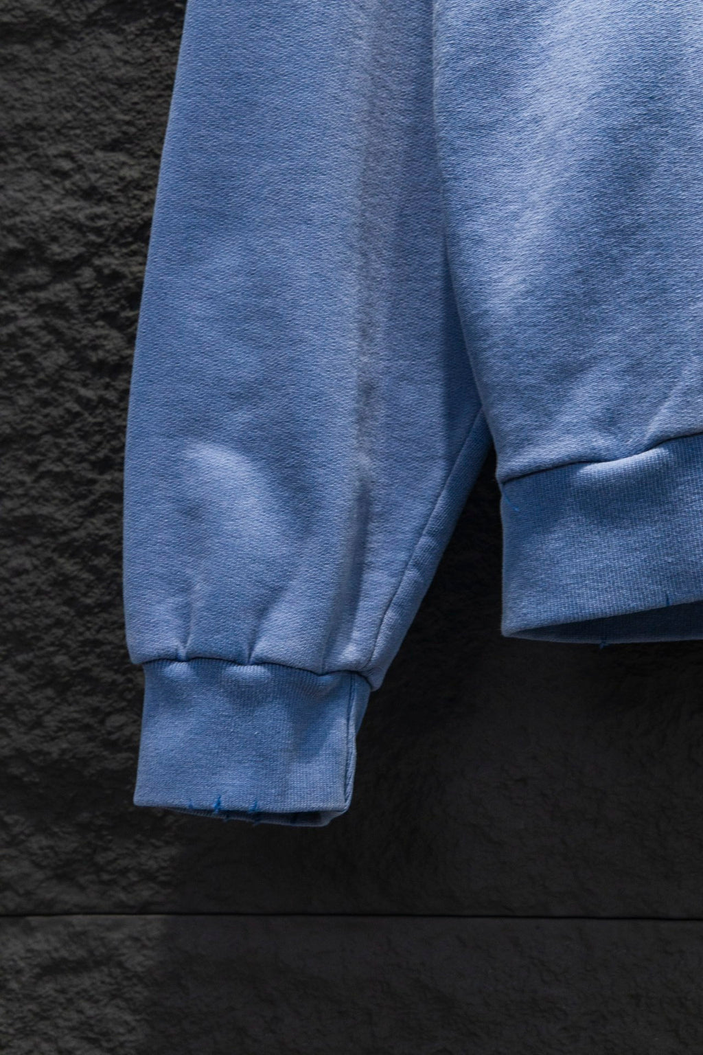 Light blue hoodie sleeve with ribbed cuff and side panel seam detail